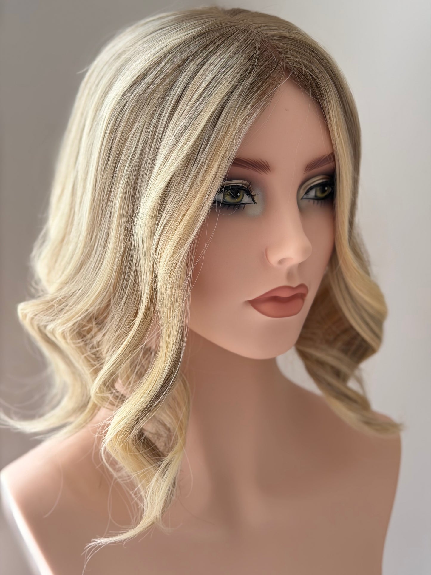 Champagne hair topper on mannequin head. 
